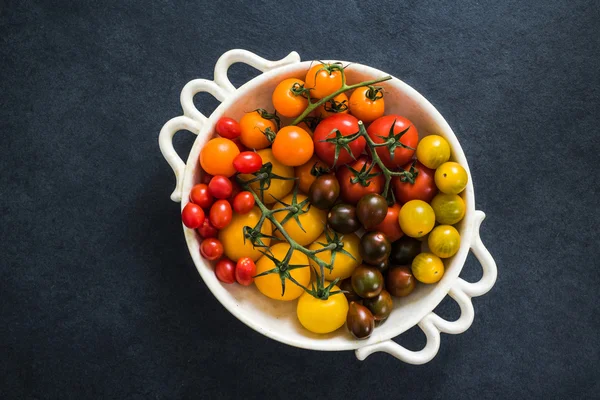 Tomaten in kom op donkere leisteen — Stockfoto