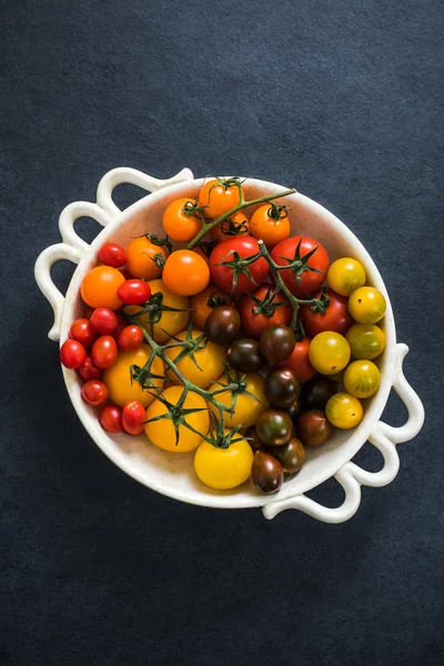 Pomidory w misce na ciemne łupki — Zdjęcie stockowe