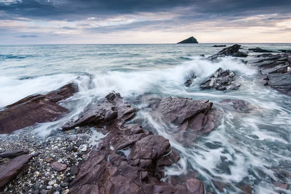 Stormy and dramatic clouds over rocky beach — Stock Photo, Image