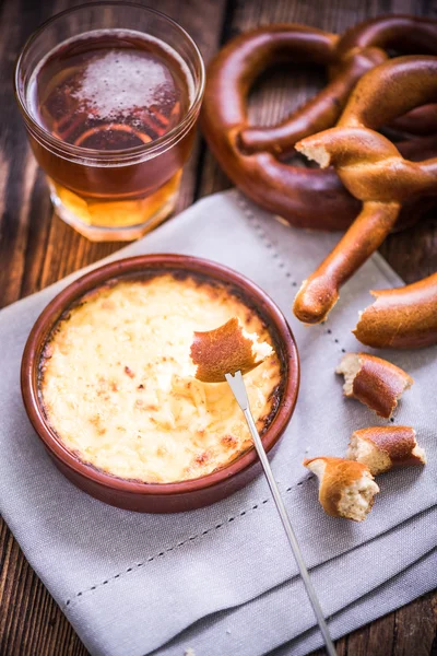 worming cheese fondue with pretzel at winter