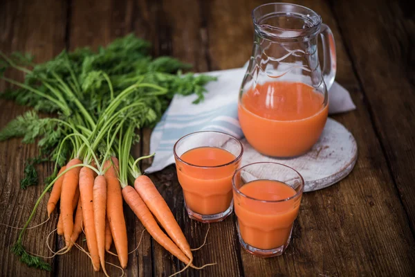 Suco de cenoura fresco em jarro e copos — Fotografia de Stock