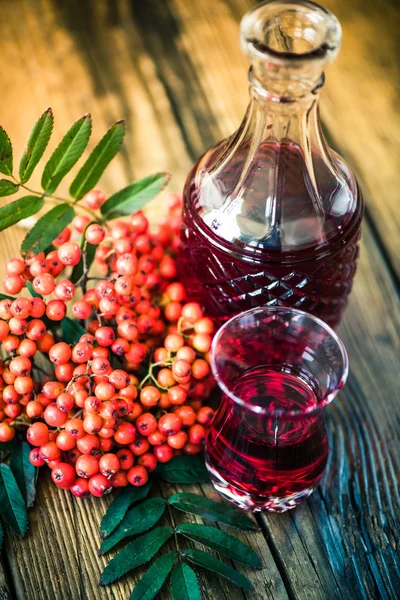 Rowanberry настойка водки на деревянный стол — стоковое фото