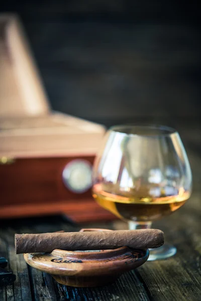 Cuban cigar and humidor in background — Stock Photo, Image