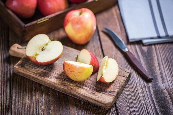 Äpplen skivas på träskiva — Stockfoto