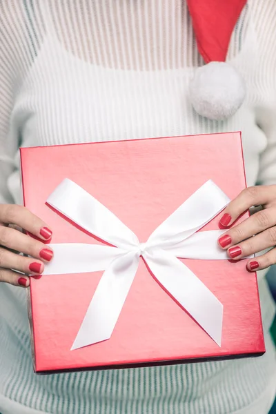 Женщина в белом трикотажном свитере провести рождественский подарок — стоковое фото