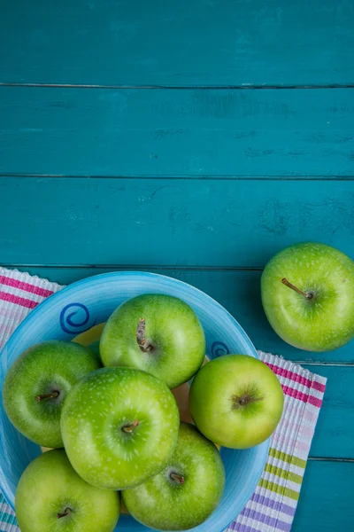 Farm fresh organic green apples on wooden retro blue table in ba