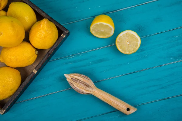 Organic lemons and juice squeezer on table — Stock Photo, Image