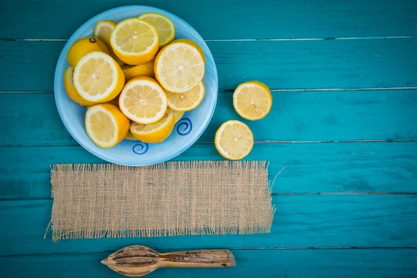 Organic lemons  halves and juice squeezer on table — Stock Photo, Image