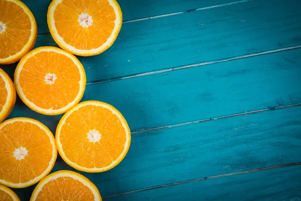 Fresh organic oranges halves  on wooden background — Stock Photo, Image