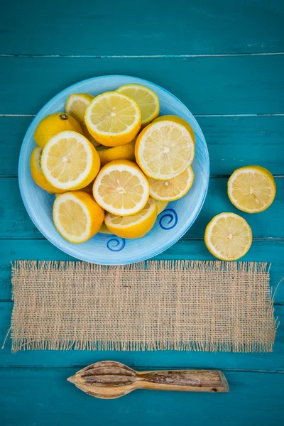 Limones orgánicos mitades y exprimidor de jugo en la mesa —  Fotos de Stock