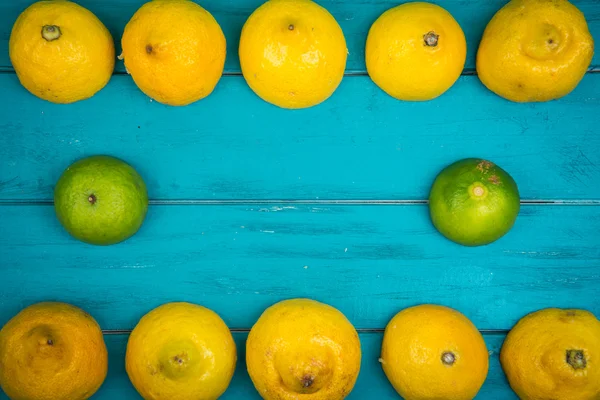 Limones y limas orgánicos frescos sobre fondo de madera —  Fotos de Stock