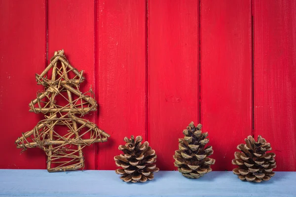 Pijnappel retro kerstboom op rode achtergrond van hout — Stockfoto