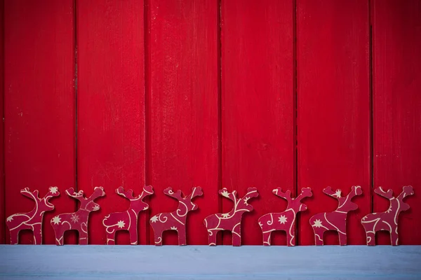 Vánoční soby na červeném pozadí dřeva — Stock fotografie