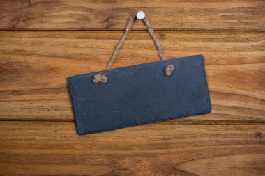 Ahşap adam üzerinde asılı ip ile taş tabela