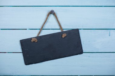 Ahşap adam üzerinde asılı ip ile taş tabela