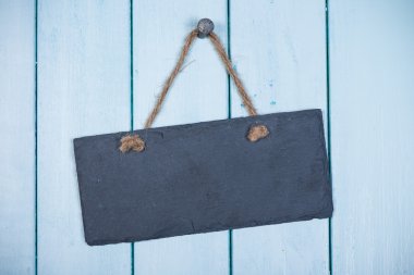 Ahşap adam üzerinde asılı ip ile taş tabela