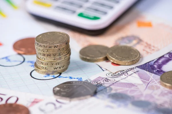 財務グラフ上のイギリスのポンド硬貨のスタック — ストック写真