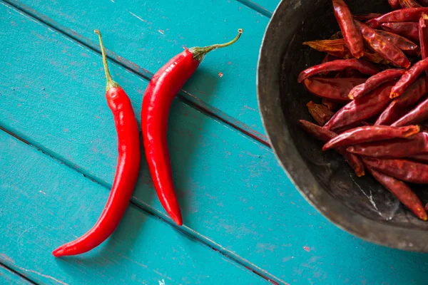 Red fresh and dried chilli peppers on table — Stock Photo, Image
