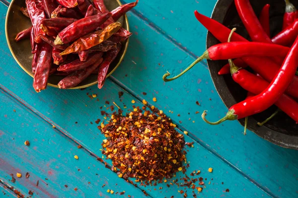 Organic vibrant red peppers and dried chilli and seeds — Stock Photo, Image