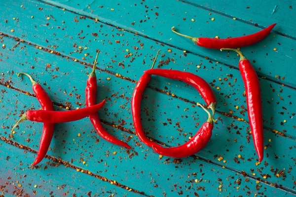 Quente feito com pimentas vermelhas vibrantes no fundo da mesa — Fotografia de Stock