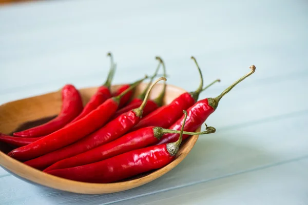 Fresh chilli in wooden bowl on table — Stock Photo, Image