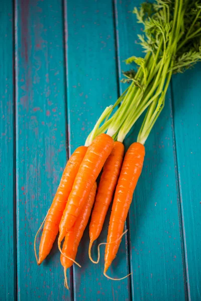 Boerderij verse wortelen op blauwe tafel — Stockfoto