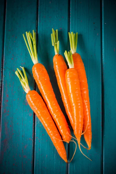 Farm fresh carrots on blue table — Stock Photo, Image