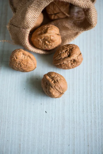 Walnuts in sack on white table — Stock Photo, Image