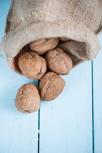 Walnuts in sack on white table — Stock Photo, Image