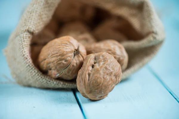 Walnuts in sack on white table — Stock Photo, Image