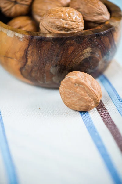 Walnut on cloth with bowl in background — Stock Photo, Image