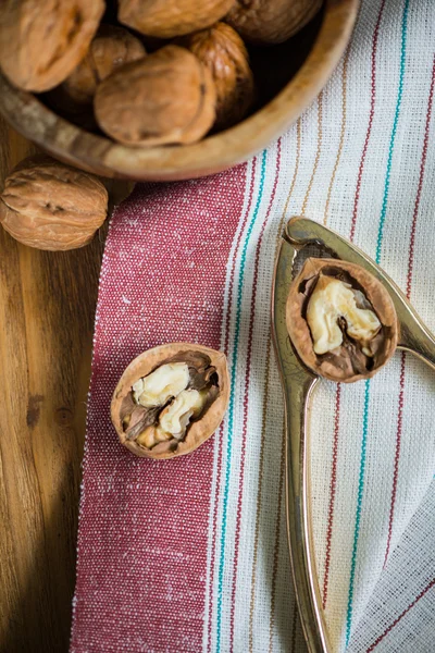 Table top view on nut cracker and open walnut — Stock Photo, Image