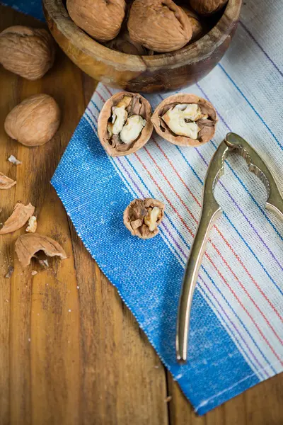 Table top view on nut cracker and open walnut — Stock Photo, Image