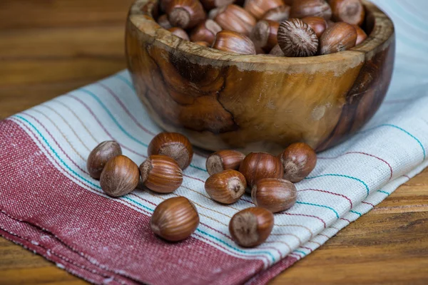 Bowl with hazelnuts on kitchen cloth — Stock Photo, Image