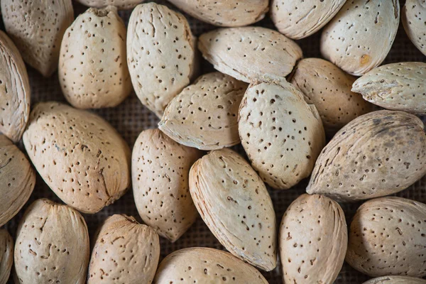 Whole almonds on wooden table — Stock Photo, Image