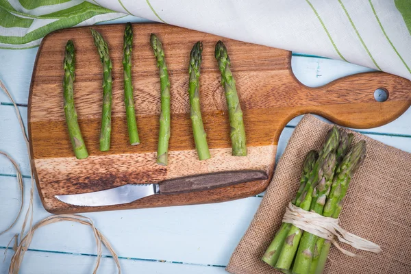 Fresh asparagus on chopping board — Stock Photo, Image