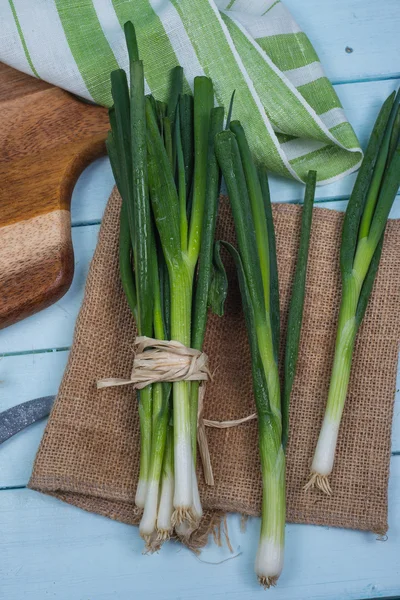 Fresh spring onion bunch on wooden table — Stock Photo, Image