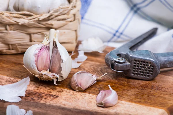 Fresh garlic and squeezer — Stock Photo, Image