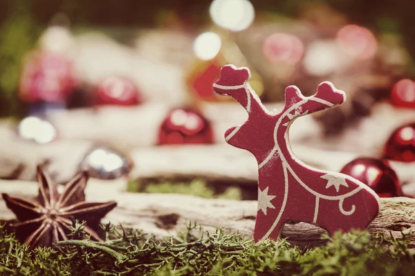 Small reindeer on natural moss and Christmas decorations — Stock Photo, Image