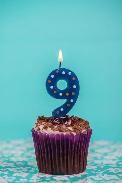 Pastel de la taza de cumpleaños con número nueve vela sobre fondo azul — Foto de Stock