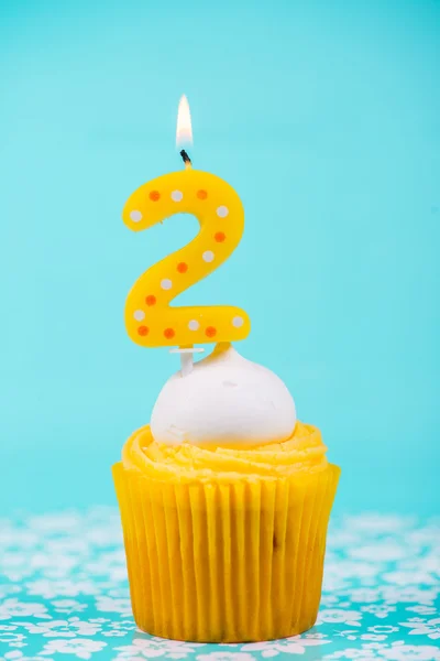 青い背景の 2 つの番号キャンドルとバースデー カップ ケーキ — ストック写真