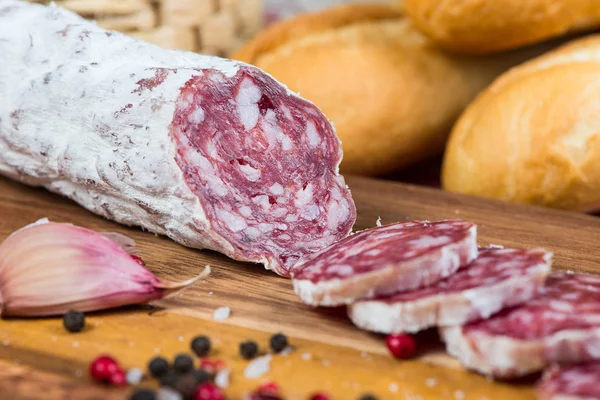 Sliced salami on wooden board — Stock Photo, Image