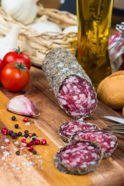 Dry sausage with herbs and olive oil on table — Stock Photo, Image