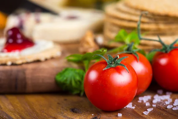 Fresh organic tomatoes with basil and rock salt — Stock Photo, Image