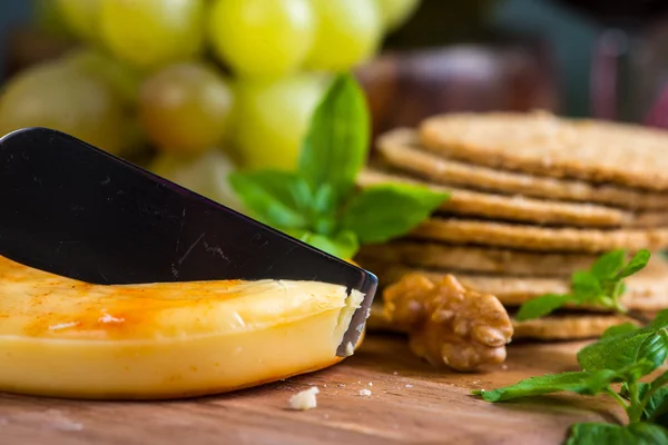 Close view on cheese with oat cakes and walnut on board — Stock Photo, Image