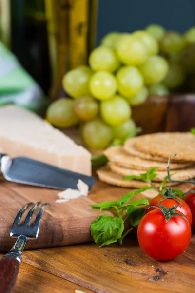 Tomates cherry ecológicos y queso parmesano en la mesa —  Fotos de Stock