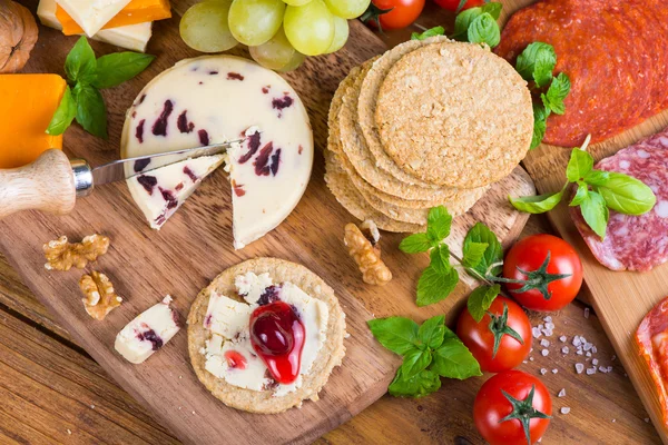 Healthy starters on rustic wooden cheese board — Stock Photo, Image