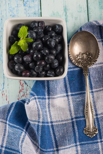 Pot with fresh blueberries mint leaf and silver spoon — Stock Photo, Image