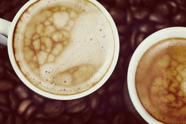 Expresso crémeux frais sur fond de grains de café torréfiés — Photo