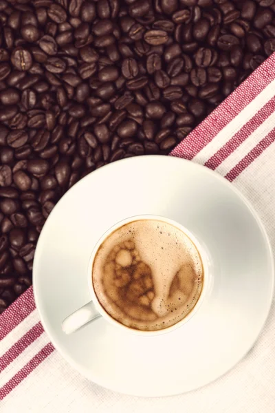 Taza de expresso cremoso sobre granos de café tostados — Foto de Stock